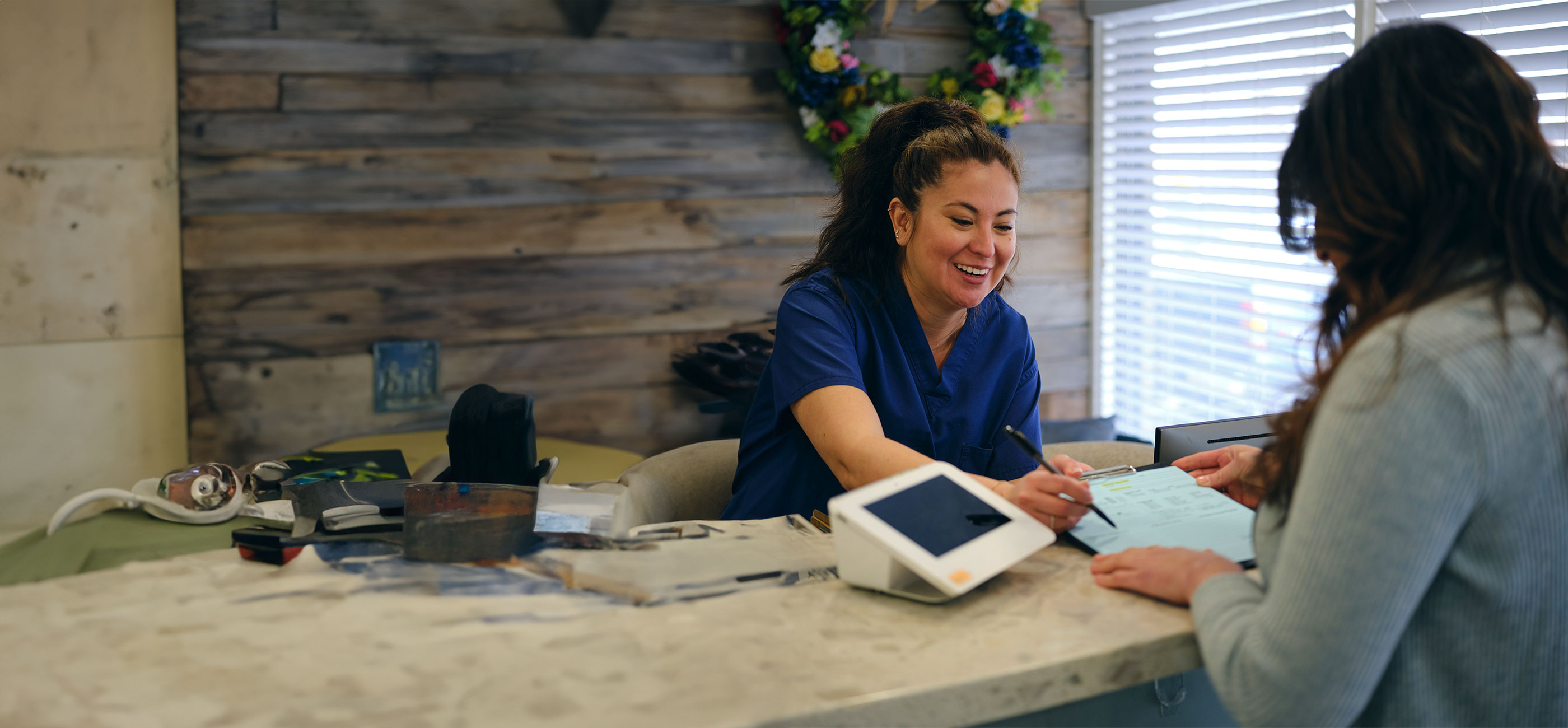 woman checking in at front desk of healthcare facility