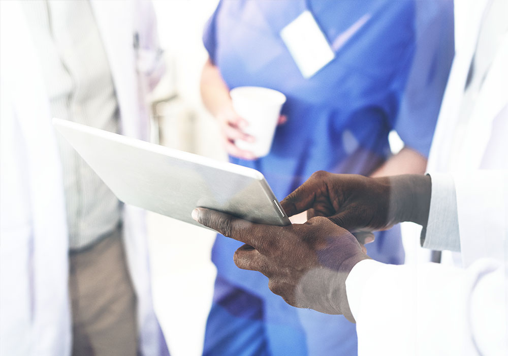 Physicians reviewing data on a tablet having a discussion